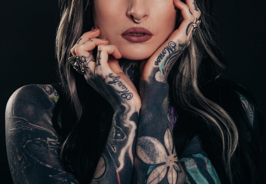 Retrato de una mujer adornada con una vibrante variedad de tatuajes en su cuerpo.